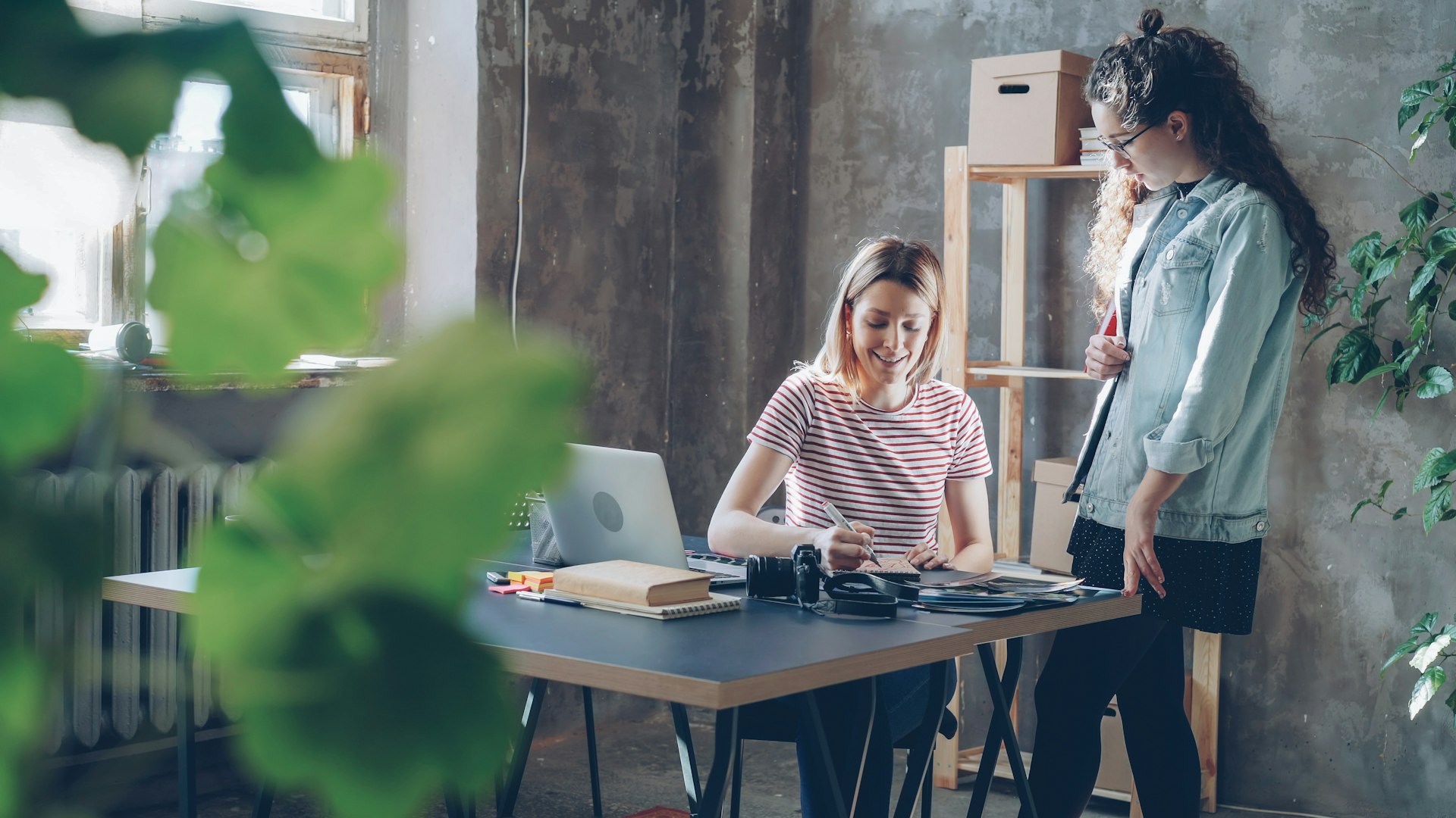 Two women collaborate at a desk.